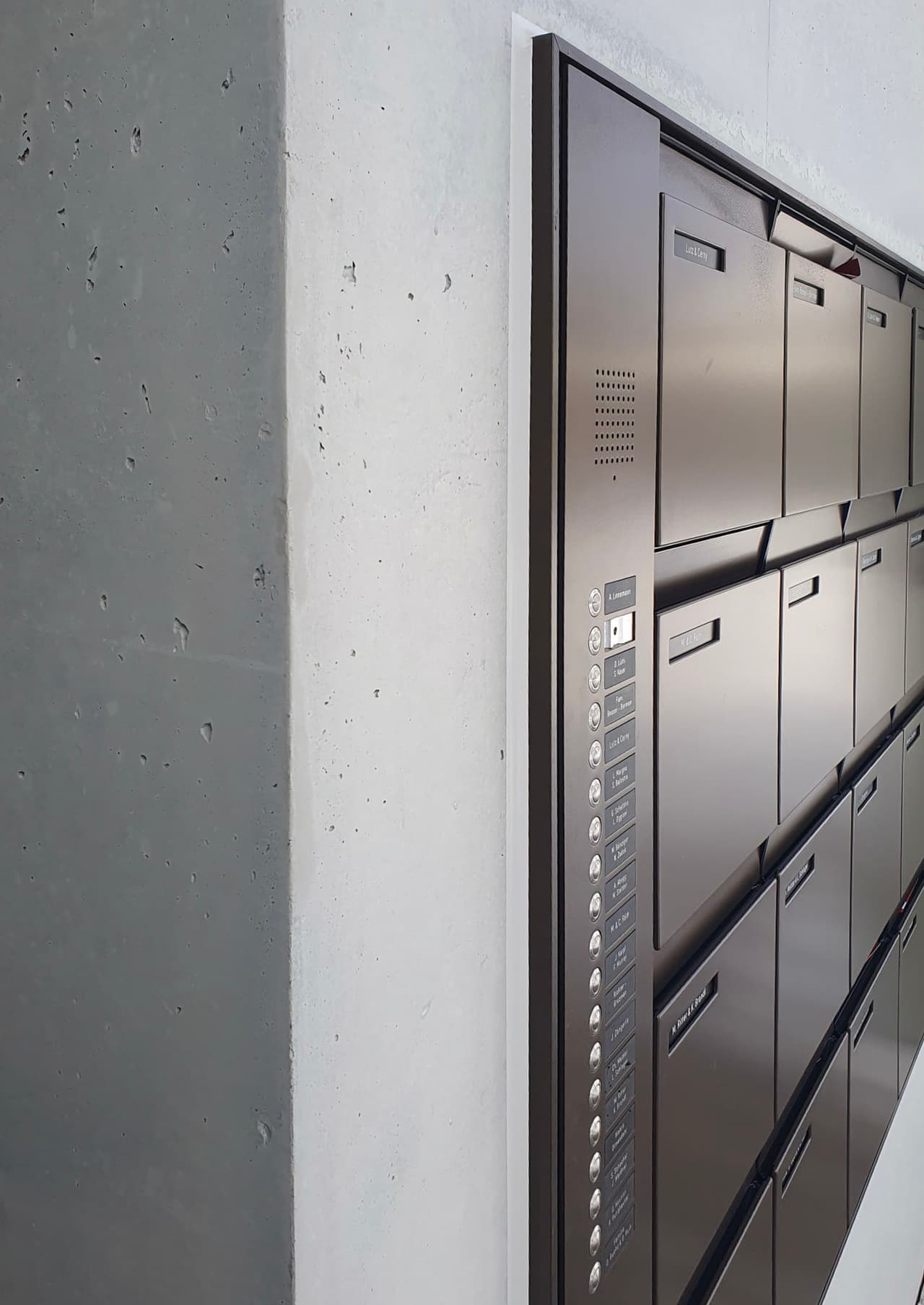 Briefkasten- und Gegensprechrahmen mit weißer Fuge an einer Betonlaibung